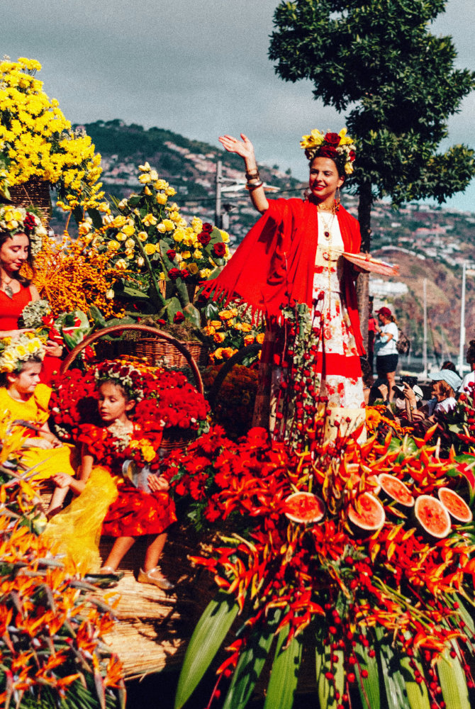 Colorful flower festival parade with people in costumes.